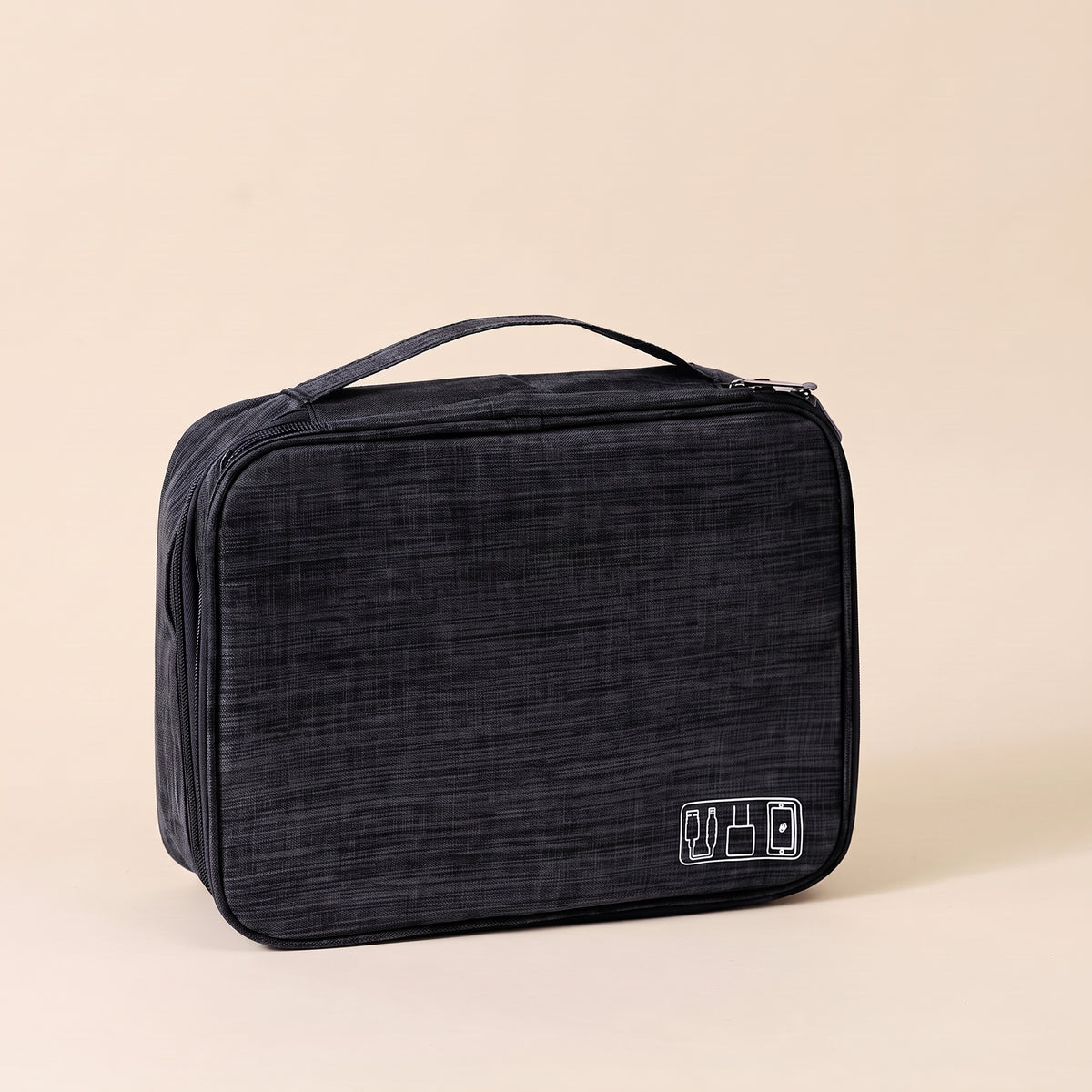 Stowmade tech organiser closed, black heather fabric with carry handle, on a warm sand background #Black