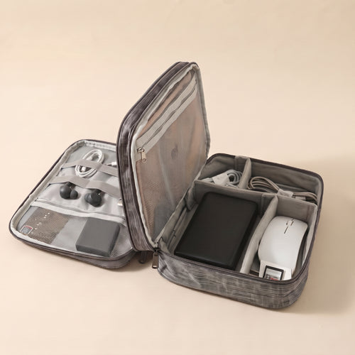 Stowmade tech organiser in grey, open on a warm sand background with cables, a power bank, a mouse and earbuds in labelled compartments #Gray